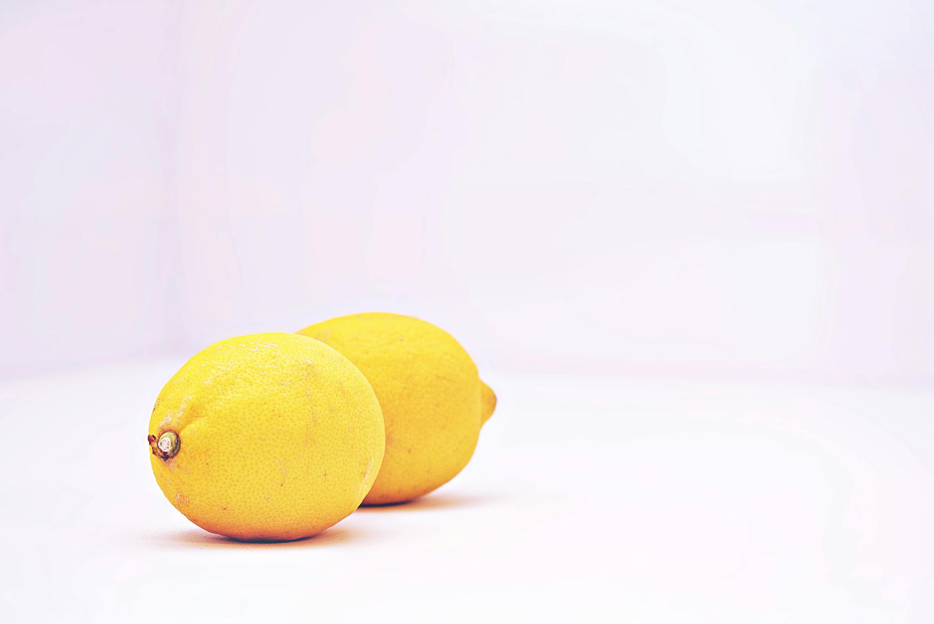 Fresh yellow lemons on a white background representing vibrant pleasure after hormonal change