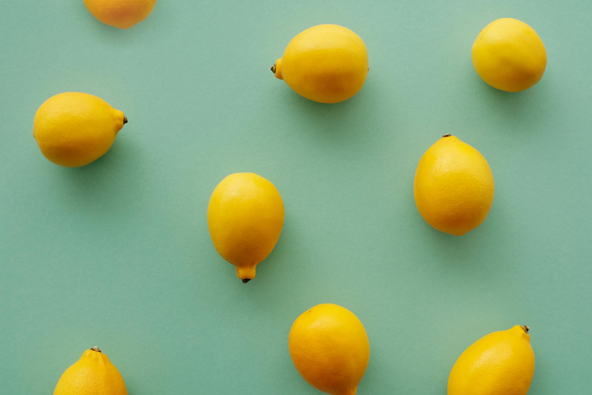 Bright yellow lemons arranged on a pastel background, representing fresh starts and renewed pleasure.