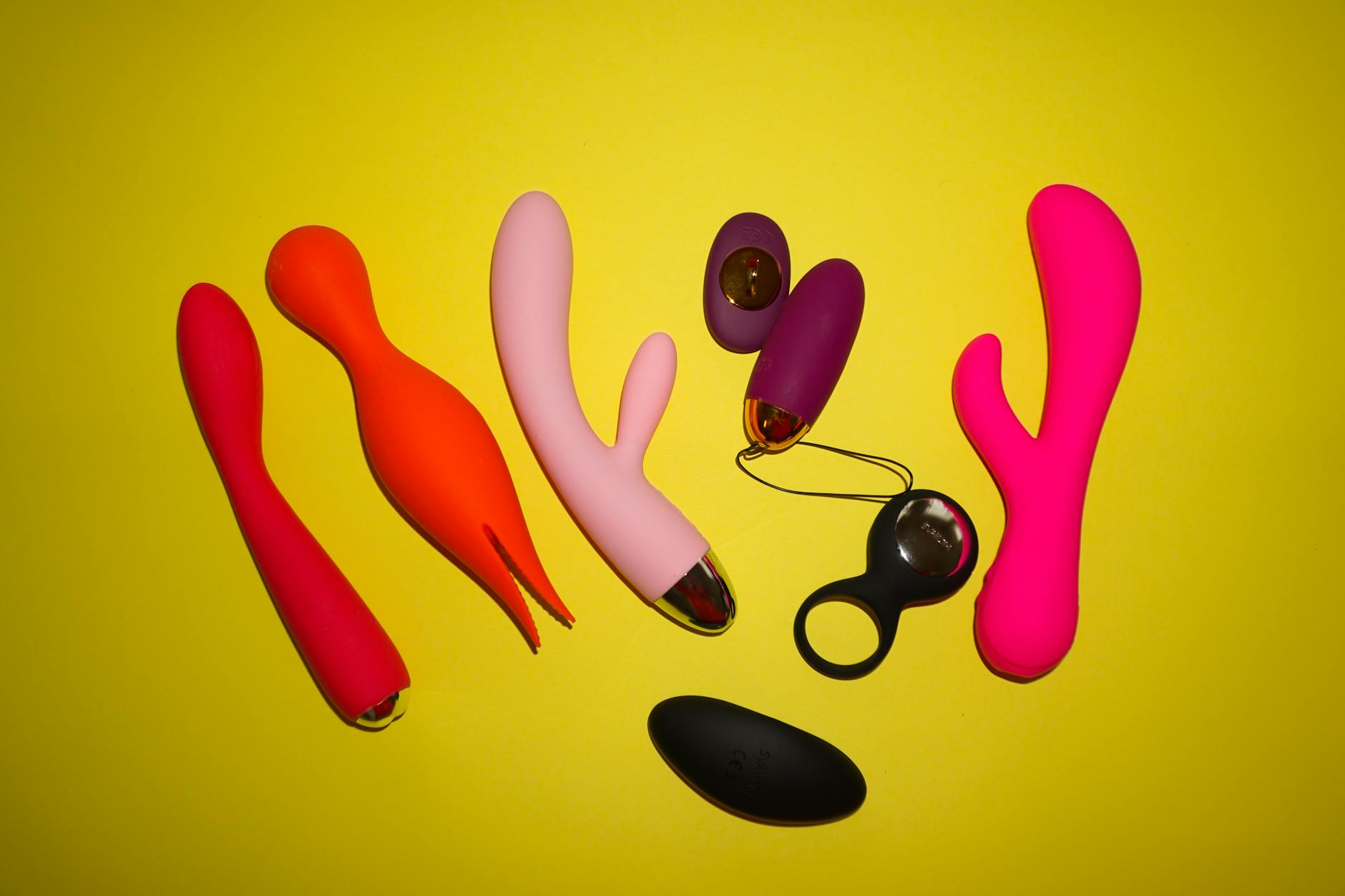A teal vibrator on smooth white silk fabric against a soft background